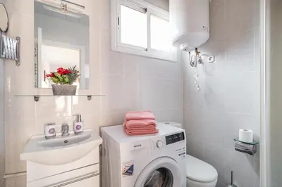 a bathroom with a washing machine and a sink at Magic Badalona House in Badalona