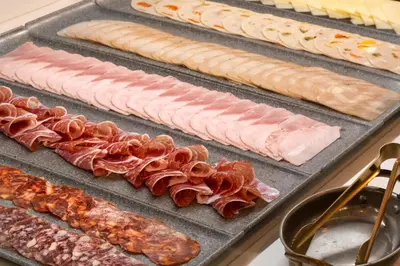 a tray of bacon and other meats and cheese at Catalonia Boulevard in Barcelona
