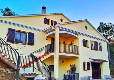 a large yellow house with stairs in front of it at Casa Donaire in Marganell