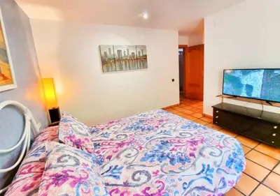 a bedroom with a bed and a flat screen tv at Casa Donaire in Marganell