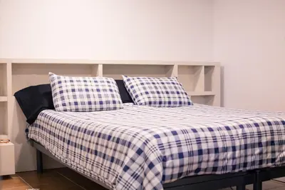 a bed with a blue and white checkered blanket at VILLA CHETRUS Casa en plena naturaleza in Rubí