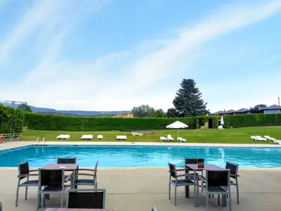 a pool with tables and chairs in front of it at Montanyà in Seva
