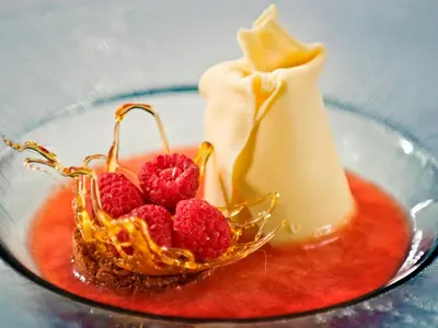 a glass bowl with a dessert with raspberries in it at Montanyà in Seva