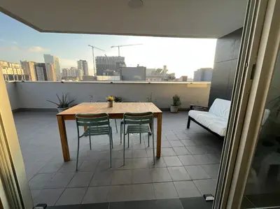 a table and chairs on a balcony with a view of a city at Beach & Culture Barcelona Port Forum Penthouse Apartment in Sant Adria de Besos