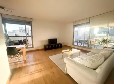 a living room with a white couch and a table at Beach & Culture Barcelona Port Forum Penthouse Apartment in Sant Adria de Besos