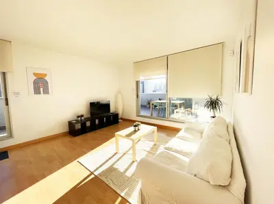 a living room with a white couch and a table at Beach & Culture Barcelona Port Forum Penthouse Apartment in Sant Adria de Besos