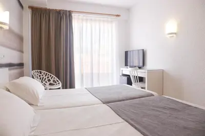 a hotel room with two beds and a television at KAKTUS Hotel Volga in Calella