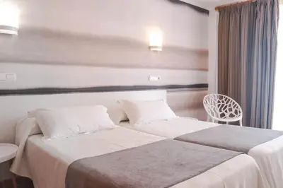 a bedroom with a bed and a painting on the wall at KAKTUS Hotel Volga in Calella