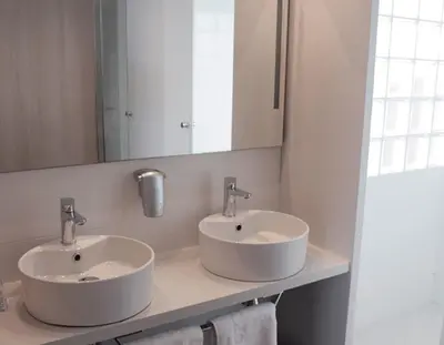 a bathroom with two sinks and a mirror at KAKTUS Hotel Volga in Calella