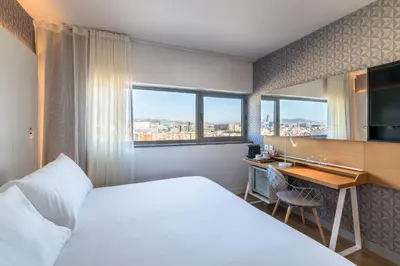 a hotel room with a bed and a desk at Occidental Atenea Mar - Adults Only in Barcelona