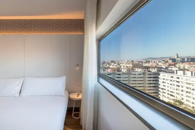 a bedroom with a bed and a large window at Occidental Atenea Mar - Adults Only in Barcelona