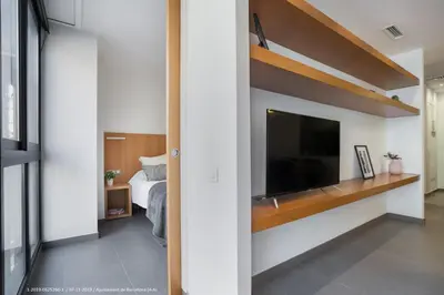 a bedroom with a large flat screen tv and a bed at Flateli Navas D01 in Barcelona