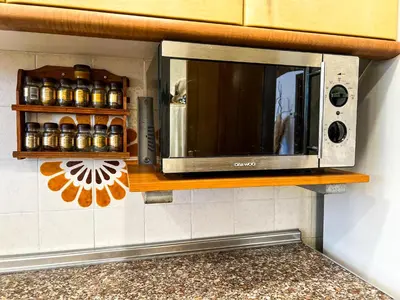 a microwave on a shelf in a kitchen at Vivalidays Casa Ricardo in Sant Cebrià de Vallalta