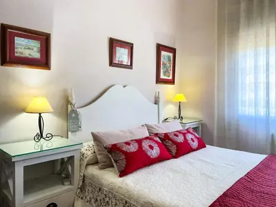 a bedroom with a bed with red pillows on it at Vivalidays Casa Ricardo in Sant Cebrià de Vallalta