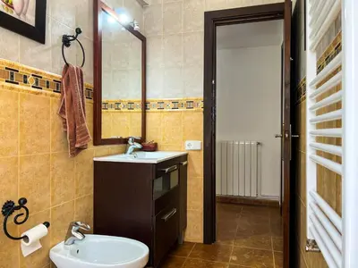 a bathroom with a sink and a toilet and a mirror at Vivalidays Casa Ricardo in Sant Cebrià de Vallalta