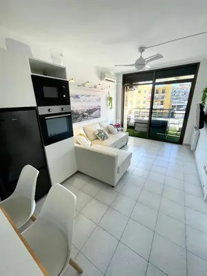 a living room with a couch and a table and chairs at Apartemento piscina centro calella 3 min playa in Calella