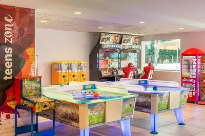 a childrens play room with two tables and a machine at FERGUS Club Pineda Splash in Pineda de Mar