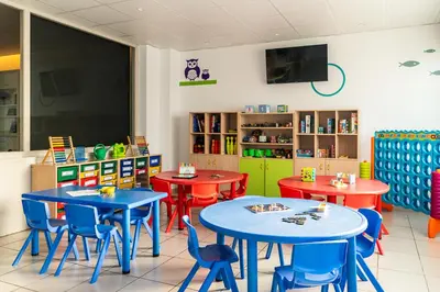 a classroom with tables and chairs in a classroom at FERGUS Club Pineda Splash in Pineda de Mar