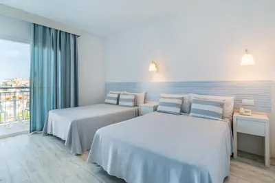a hotel room with two beds and a window at FERGUS Club Pineda Splash in Pineda de Mar
