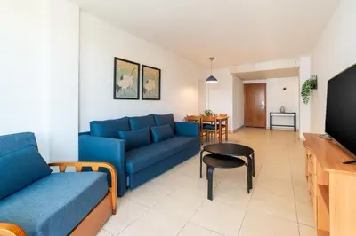 a living room with a blue couch and a table at FERGUS Club Pineda Splash in Pineda de Mar
