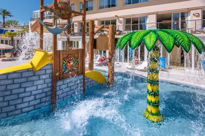 a water park with a palm tree and a water slide at Hotel Oasis Park Splash in Calella