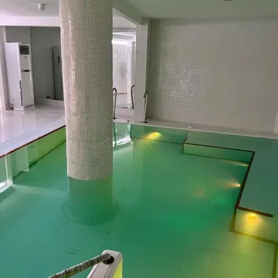 an empty room with green floors and a pole at Hotel Oasis Park Splash in Calella