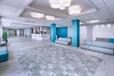 an office lobby with couches and a rug at Hotel Oasis Park Splash in Calella