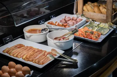 a buffet of food with meat and eggs on a counter at Hotel del Mar in Barcelona