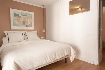 a bedroom with a white bed and a painting at Click&Flat Stylish Torrijos in Barcelona