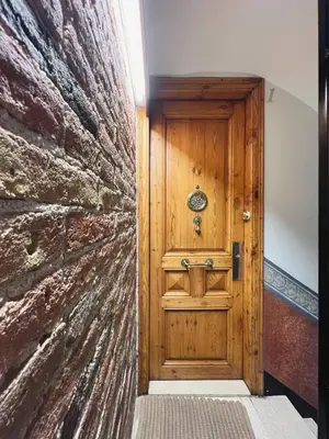 a wooden door in a room with a stone wall at Stay U-nique Apartments Murillo in Barcelona