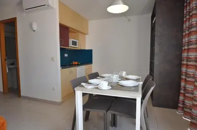 a kitchen with a white table and chairs and a table and chairsktop at Aparthotel Safari in Calella