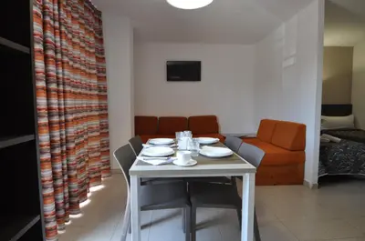 a white table with chairs and a couch in a room at Aparthotel Safari in Calella