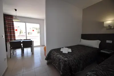 a hotel room with a bed and a dining room at Aparthotel Safari in Calella