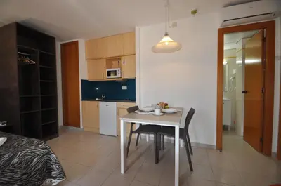 a kitchen and dining room with a table and chairs at Aparthotel Safari in Calella