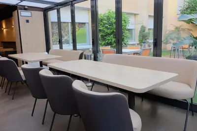 two tables and chairs in a room with windows at Aparthotel Silver in Barcelona