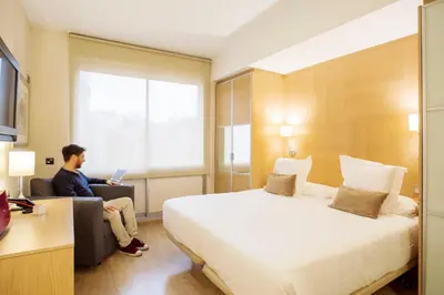 a man sitting in a hotel room with a laptop at Aparthotel Silver in Barcelona