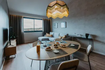 a living room with a table and a couch at Petit Luxe Volta ÀTIC in Terrassa