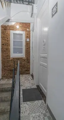 a hallway with a staircase and a window and a door at Fira BOUTIQUE by MyRentalHost in Hospitalet de Llobregat