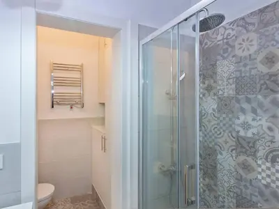 a bathroom with a glass shower with a toilet at Colour Pop FIRA by MyRentalHost in Hospitalet de Llobregat