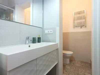 a white bathroom with a sink and a toilet at Colour Pop FIRA by MyRentalHost in Hospitalet de Llobregat