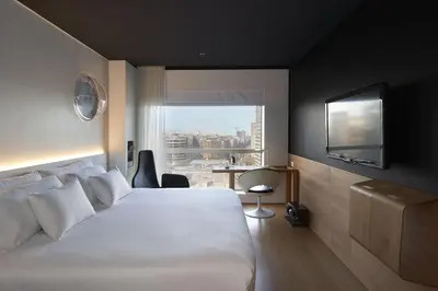 a hotel room with a large bed and a window at Barceló Sants in Barcelona