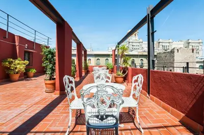 a patio with white chairs and tables on a balcony at Hotel Gótico in Barcelona