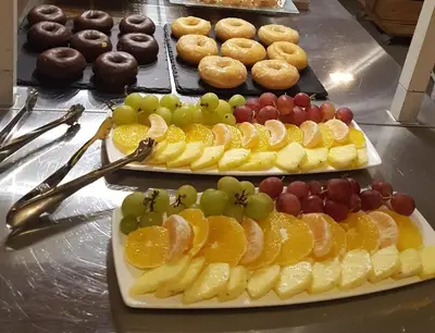 two plates of fruit on a table with donuts and donuts at Cèsar in Vilanova i la Geltrú