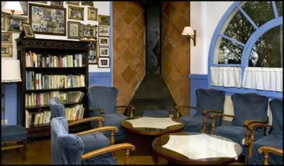 a library with chairs and a book shelf with books at Cèsar in Vilanova i la Geltrú