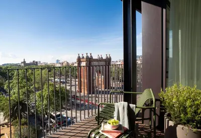 a green chair on a balcony with a towel at Archie Living in Barcelona