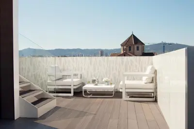 two white chairs and a sink on a balcony at Gaudi Hotel in Barcelona
