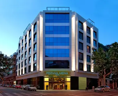 a building on a street with cars parked in front at Pestana Arena Barcelona in Barcelona