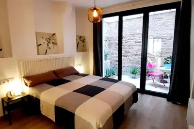 a bedroom with a bed and a large window at Acogedor apartamento con entrada independiente in Barcelona