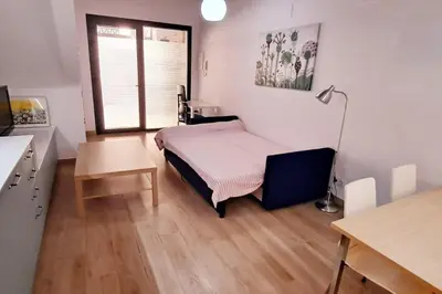 a bedroom with a bed and a desk and a window at Acogedor apartamento con entrada independiente in Barcelona