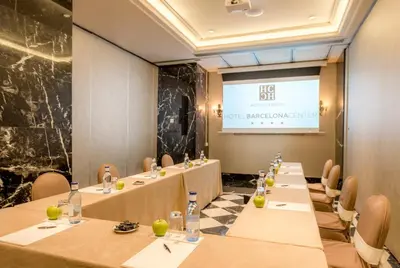 a meeting room with long tables and a projection screen at Hotel Barcelona Center in Barcelona